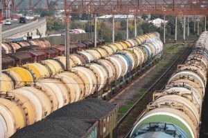Rows of colorful freight trains carrying cargo in an outdoor railway station.