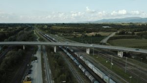 Freight train with containers traveling under a bridge in Offenburg, Germany.