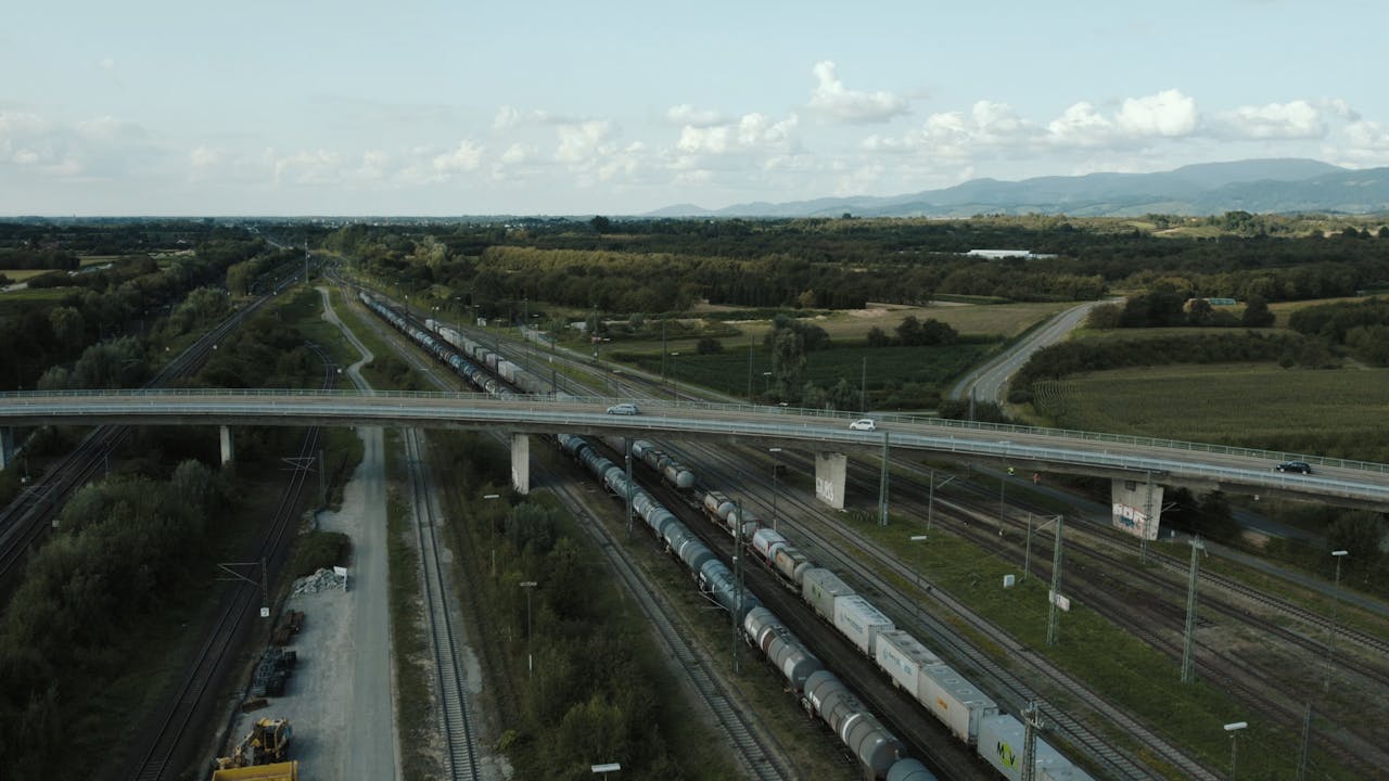 Freight train with containers traveling under a bridge in Offenburg, Germany.